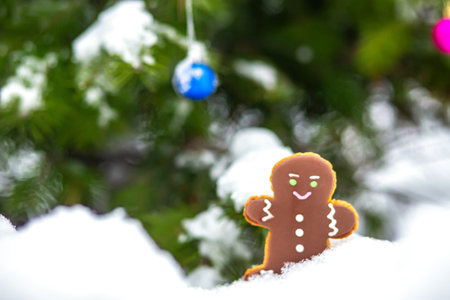 Gingerbread figures on the background of a snowy scene, next to a beautifully decorated Christmas...