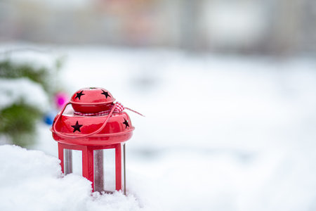 Holiday season with a radiant red lantern. Festive atmosphere of winter in the park near a snowy Christmas tree.の写真素材