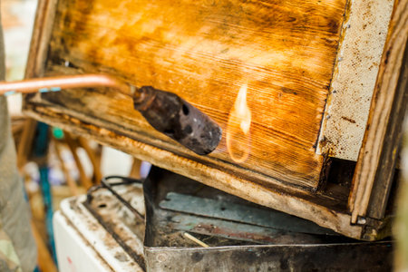 Processing of bee frames and hives for the honey harvest season. Firing the wooden parts of the hive with a blowtorch. Beekeeping work in the spring and after winter.の写真素材