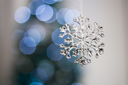 silver snowflakes and illuminated garland with flashlights. New Year bauble macro photo. Winter holiday light decoration. Copy spaceの写真素材