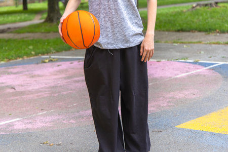 Person Holding Basketball on Outdoor Court During Daytimeの写真素材