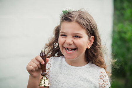 Girl holding bell and laughing.