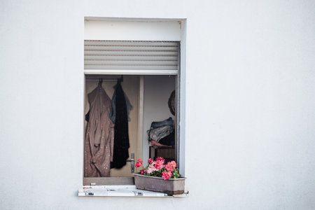 Open window with flower box and hanging clothesの写真素材