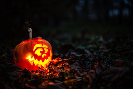 A glowing carved pumpkin head creating a spooky Halloween background in the dark.の写真素材