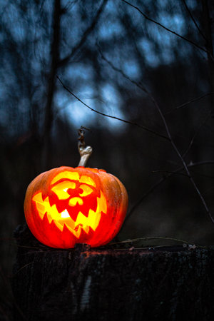 Creepy Halloween jack-o -lantern glowing brightly with an eerie expression.の写真素材