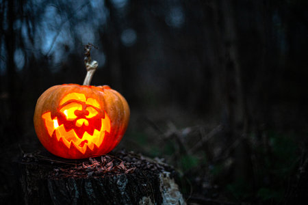 Halloween lantern pumpkin glowing in shadows, perfect for spooky backgrounds.の写真素材