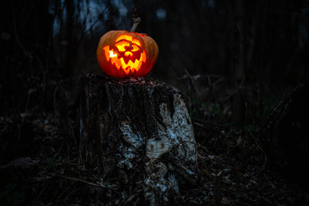 Creepy Halloween jack-o -lantern glowing brightly with an eerie expression.の写真素材