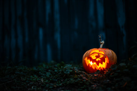 Halloween lantern pumpkin glowing in shadows, perfect for spooky backgrounds.の写真素材