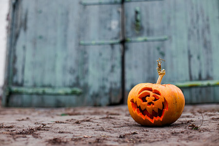 Spooky carved pumpkin lantern glowing in a mysterious atmosphere.の写真素材