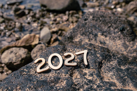 Numbers made of stones near the water on a rockの写真素材