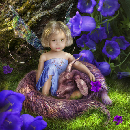 Little fairy fairy sitting in the forest with an unusual blue beast like a kidの写真素材
