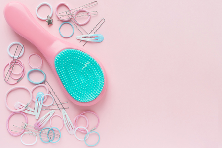 Hair scrunchies and hairpins, hairbrush on pink background, beauty concept. flat lay. free space for textの写真素材