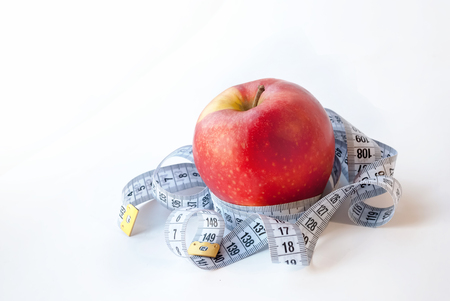 Red Apple and measuring tape on white background. Diet conceptの写真素材