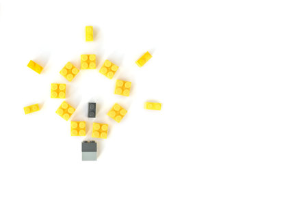 Idea concept. Lamp made of plastic constructor bricks on white background.