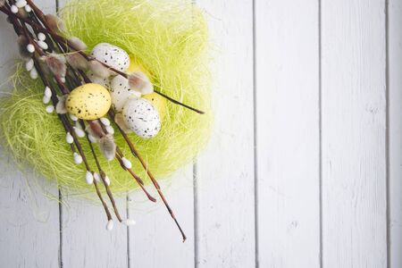 Easter decorations. Willow twigs and decorative Eggs in nests on wooden backgroundの写真素材