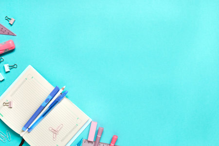 Colorful school suplies against light blue background with copy space. Back to school concept, top...