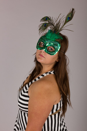 Beautiful Curvy Teenage Girl in Black and White Dress with Green Maskの写真素材