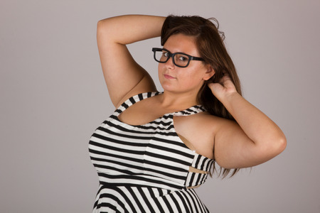 Beautiful Curvy Teenage Girl in Black and White Striped Dress and Glassesの写真素材