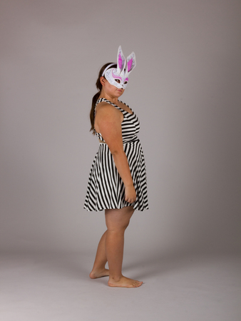 Beautiful Curvy Teenage Girl in Black and White Striped Dress White Bunny Maskの写真素材