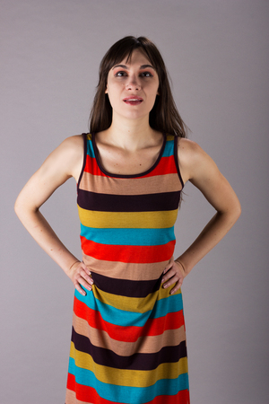 Young Girl in Stretch Dress on Grey Background Chin Up Standingの写真素材