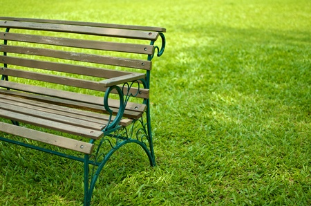 partially side view of wood seat with metal structure bench on grassの写真素材