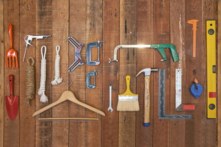 various kind of hand tools and equipments hang on vertical stripe wood boardの写真素材