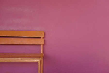 patrial bright orange wood bench on vivid pink color wall backgroundの写真素材