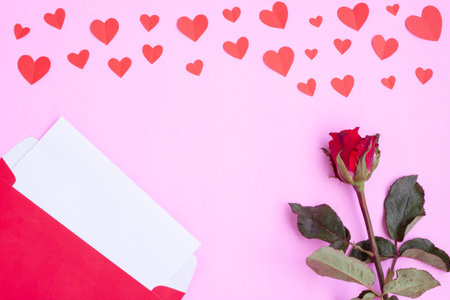 Red envelope with white greeting card, red heart papercut and red rose
