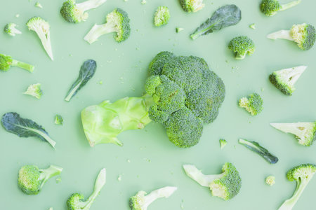 Broccoli on a green background. Flat lay, top view.
