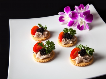 Canape made from biscuit, tuna pate, tomato, pasley and caviar.の写真素材