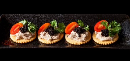 Canape made from biscuit, tuna pate, tomato, pasley and caviar.の写真素材