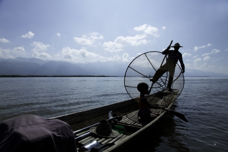 Inle Lake, Myanmar - circa Nov 2013  Burmese man rowing a small boat in Inle Lake  The Inle natives are famous for their unique leg rowing technique の写真素材