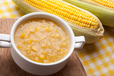 Corn chowder and fresh corn on wood butcher.の写真素材