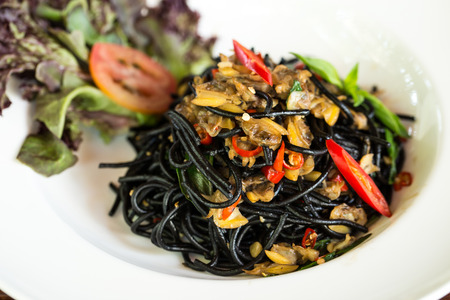Black spaghetti with clams and chilli.の写真素材