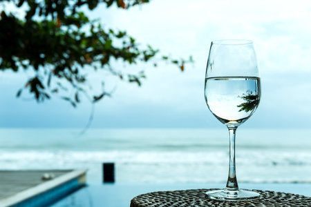 Reflection of a glass of water on beach front.の写真素材