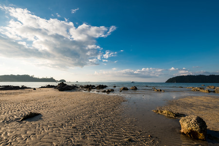 Wet sand and the rock on the seashore when low tide in the evening.の写真素材