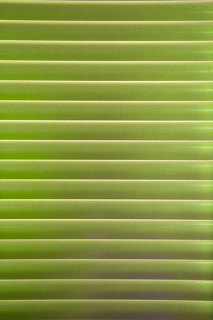 Horizontal pattern of lime venetian blinds in a gradation of colorの写真素材
