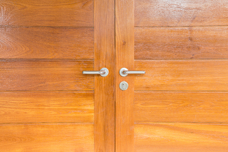 Modern metal door handle on wooden doorの写真素材