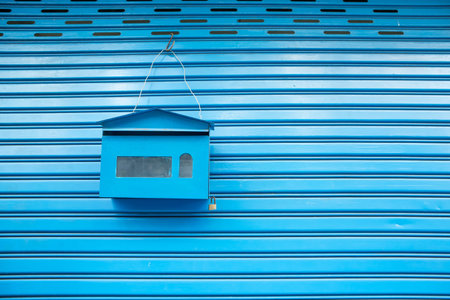 blue mailbox hanging on the roller shutter doorの写真素材