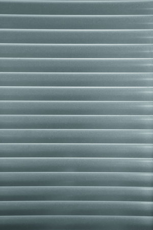 Horizontal pattern of grey venetian blinds in a gradation of colorの写真素材
