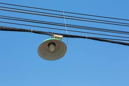 Lanterns on cables. Electrical cables and clutter or Street lamp & wire on blue sky.の写真素材