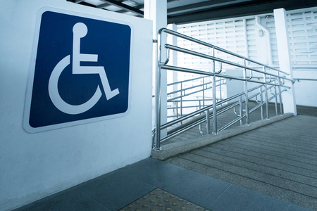 Concret ramp way with stainless steel handrail with disabled sign for support wheelchair disabled people.の写真素材
