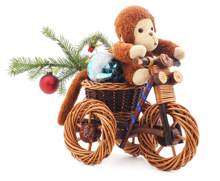 Toy monkey on a bicycle isolated on a white background.の写真素材