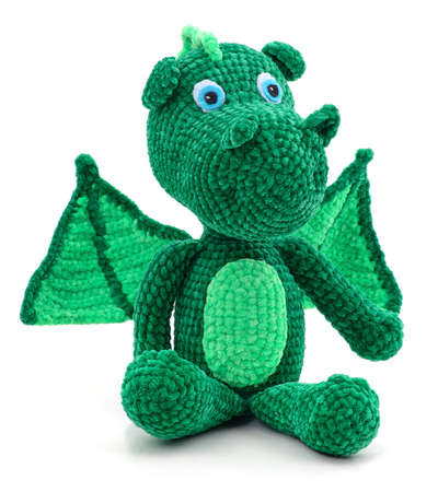 Green knitted dragon toy isolated on a white background.の写真素材