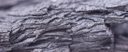 Layers of black charcoal close up forming a background.