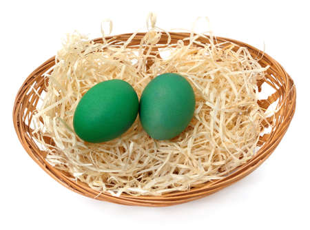Easter eggs in a basket isolated on a white background.の写真素材