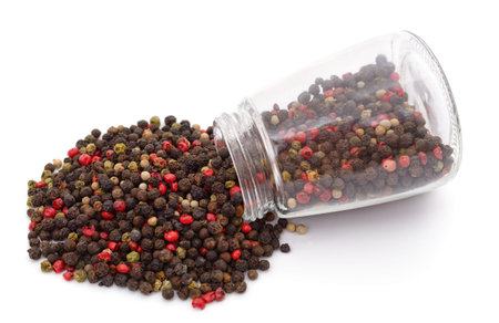Mix of different peppers in the jar isolated on a white background.