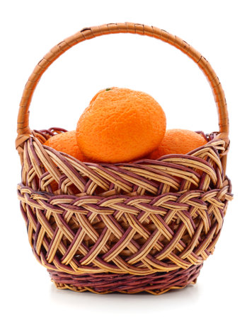 Wicker basket filled with oranges isolated on a white background.の写真素材