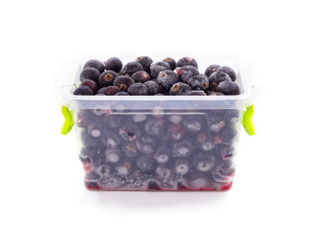 Container with frozen black currant isolated on a white background.の写真素材