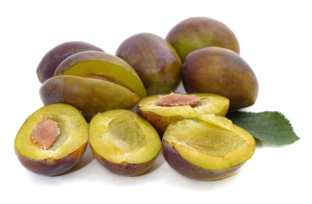 Plum halves with pits isolated on white background.の写真素材